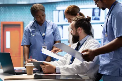 Healthcare professionals reviewing data on laptop